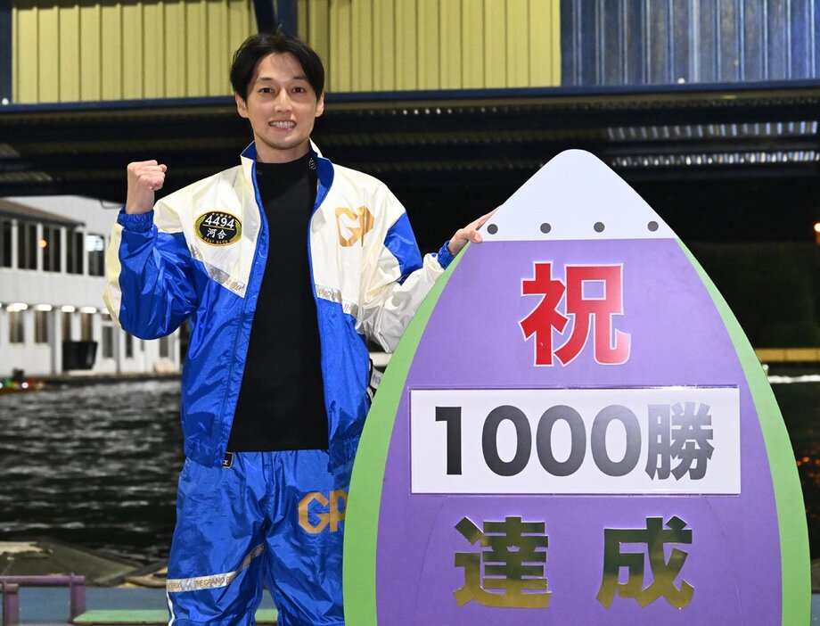 通算１０００勝を達成しパネルを手に記念撮影する河合佑樹