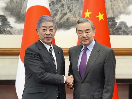 中国の王毅外相（右）と握手する岩屋外相＝25日、北京の釣魚台迎賓館（写真：共同通信社）