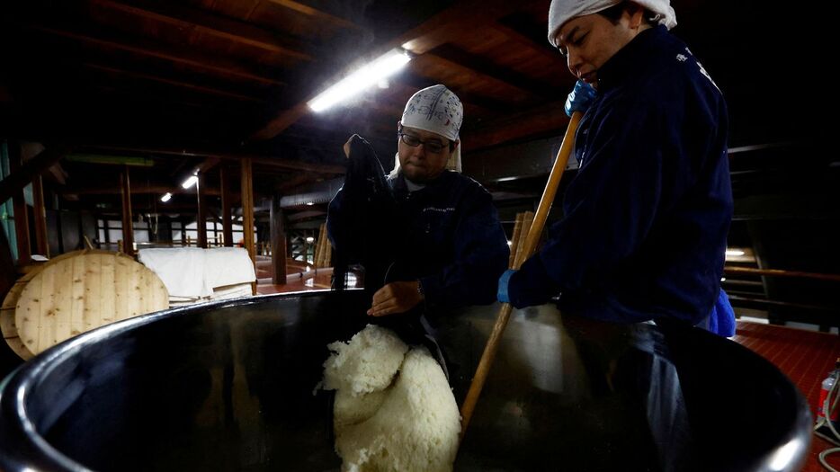 日本酒の醸造に使う酵母を作るため、蒸した酒米をかき混ぜる職人＝2024年11月25日、東京都福生市の石川酒造（ロイター）