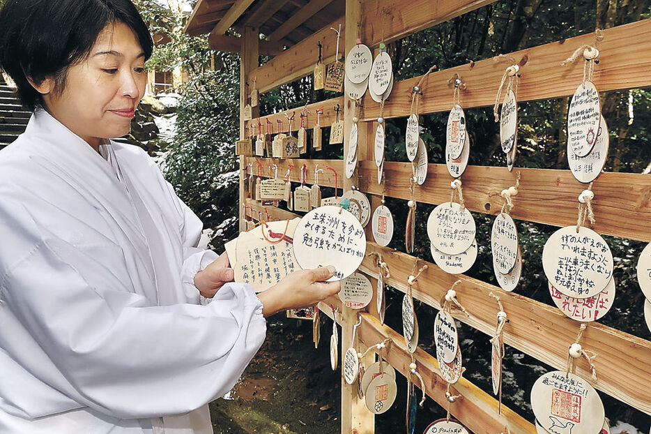 復興祈念の絵馬を飾り付ける猿女さん＝珠洲市三崎町寺家の須須神社