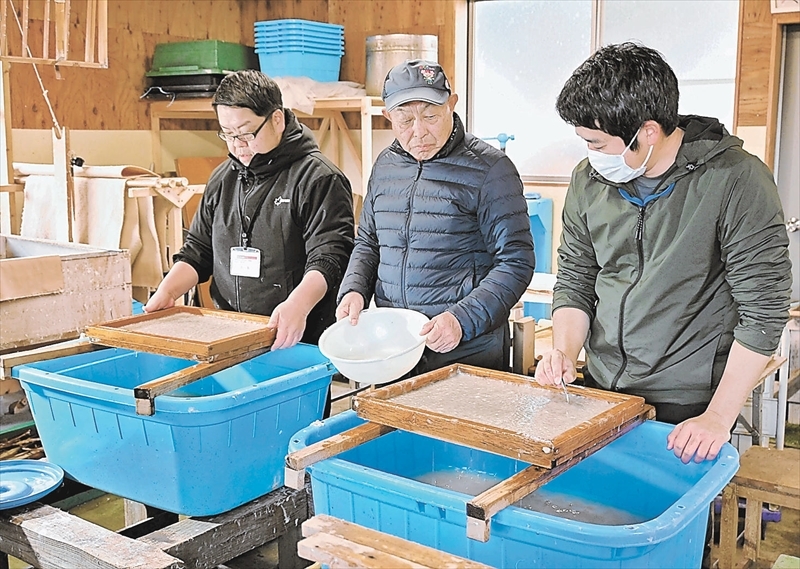 制作工程を見守る高木さん（中央）。若者のアイデアを取り入れ、新たな遠野和紙の活用法を探りたいと話す