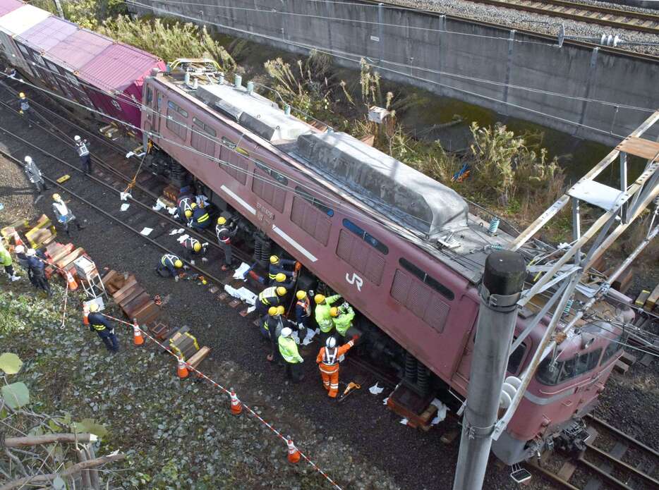 傾いた機関車を水平にする作業員ら＝１５日午前９時半ごろ、薩摩川内市の川内駅