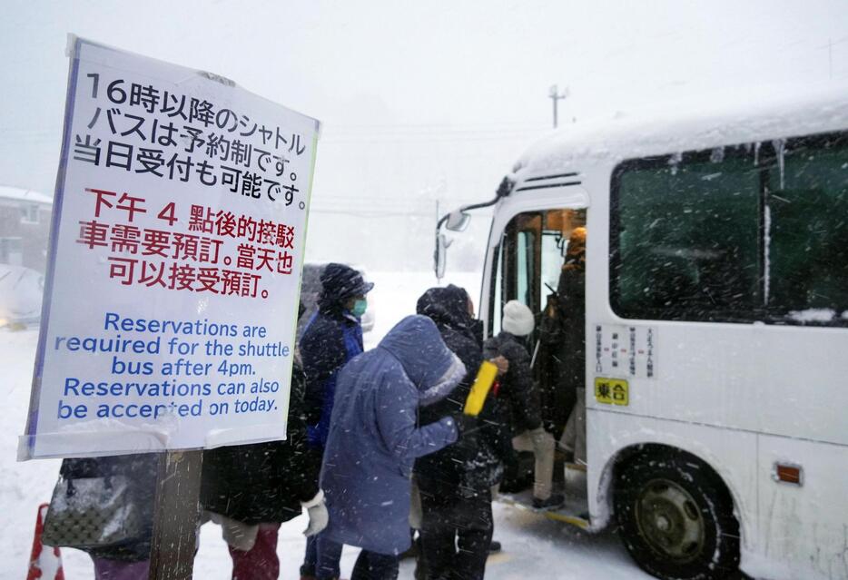 銀山温泉に向かう予約制の有料シャトルバスに乗り込む観光客＝23日午後、山形県尾花沢市