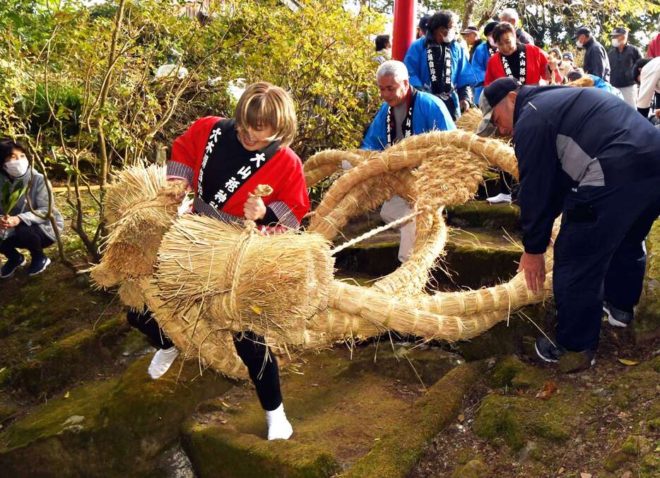 巨大草履に悪戦苦闘するる姉妹＝南さつま市大浦町