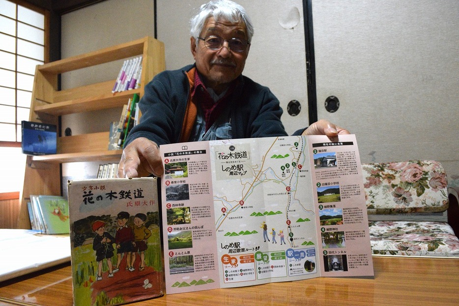 小説「花の木鉄道」と地図を紹介する伊藤会長（氏原大作交流館で）