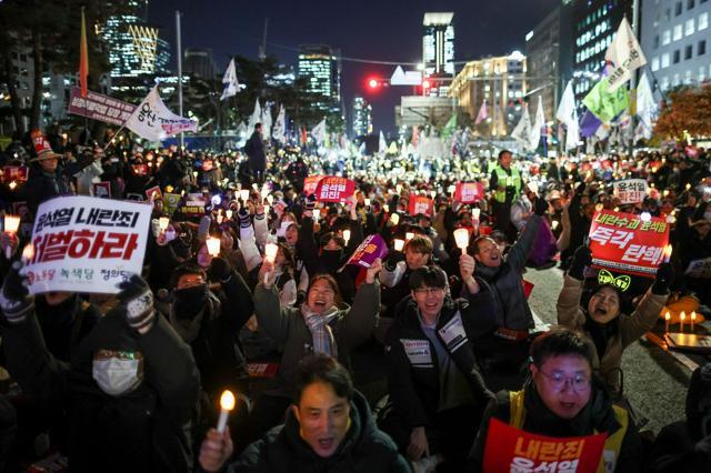 韓国・ソウルの国会前で2024年12月6日、「非常戒厳」を出した尹錫悦（ユンソンニョル）大統領の弾劾を求めてデモをする人たち=ロイター