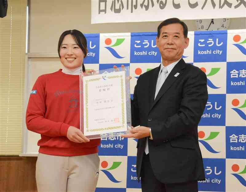 荒木義行市長（右）から合志市ふるさと大使の委嘱状を受け取った竹田麗央選手＝24日、合志市