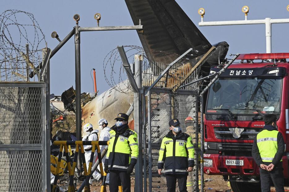 29日、韓国・務安国際空港で起きた旅客機事故現場で、対応にあたる当局者ら（共同）