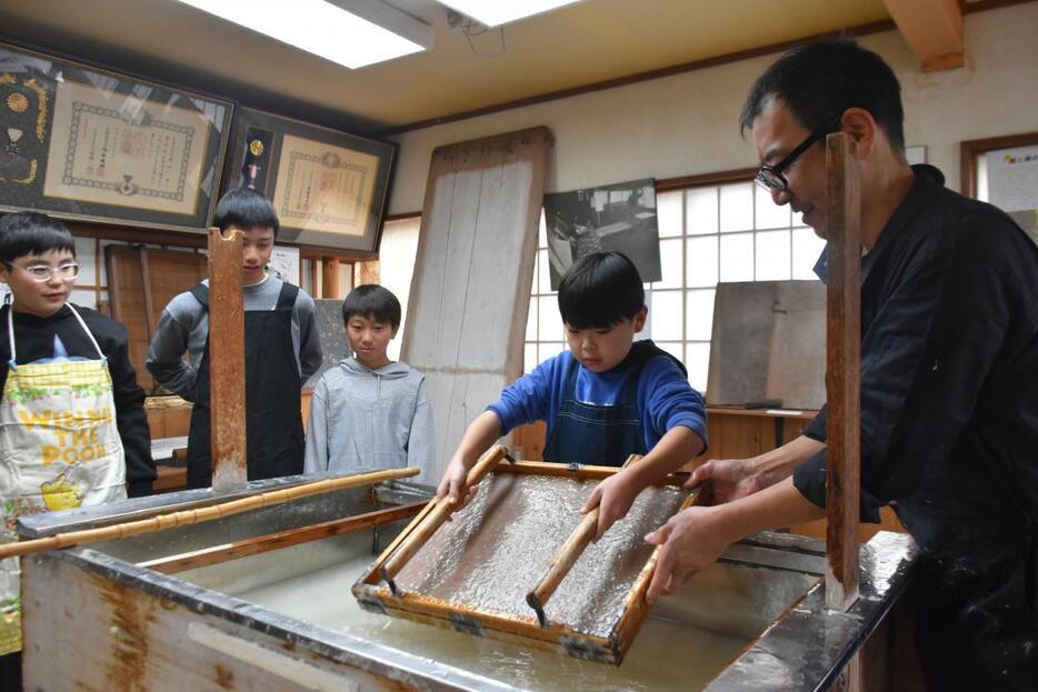 自分の卒業証書作りを紙すきから体験する山方小の6年生=常陸大宮市舟生