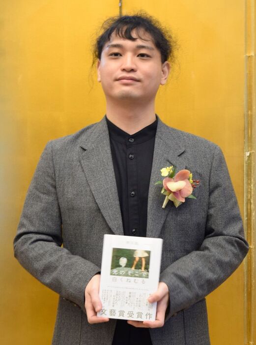 文芸賞の授賞式に合わせた記者会見で受賞作「光のそこで白くねむる」を手にする待川匙=東京都港区の明治記念館