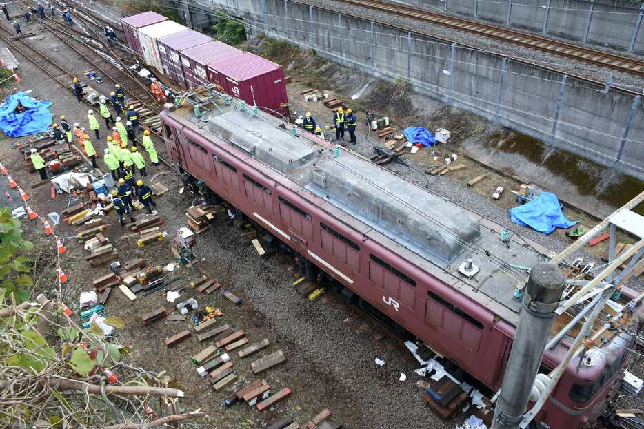 機関車と貨車の復旧作業に当たる作業員ら＝１８日午後１時４５分ごろ、薩摩川内市