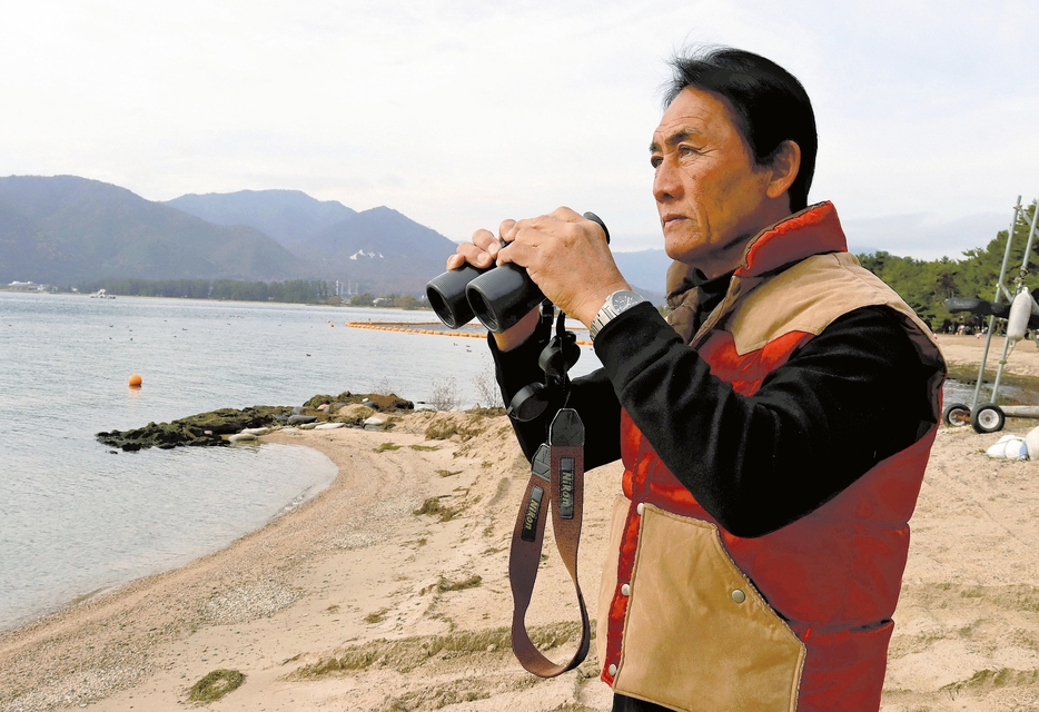 危険な船舶がないか湖上に目を光らせる伊勢田さん（滋賀県高島市で）