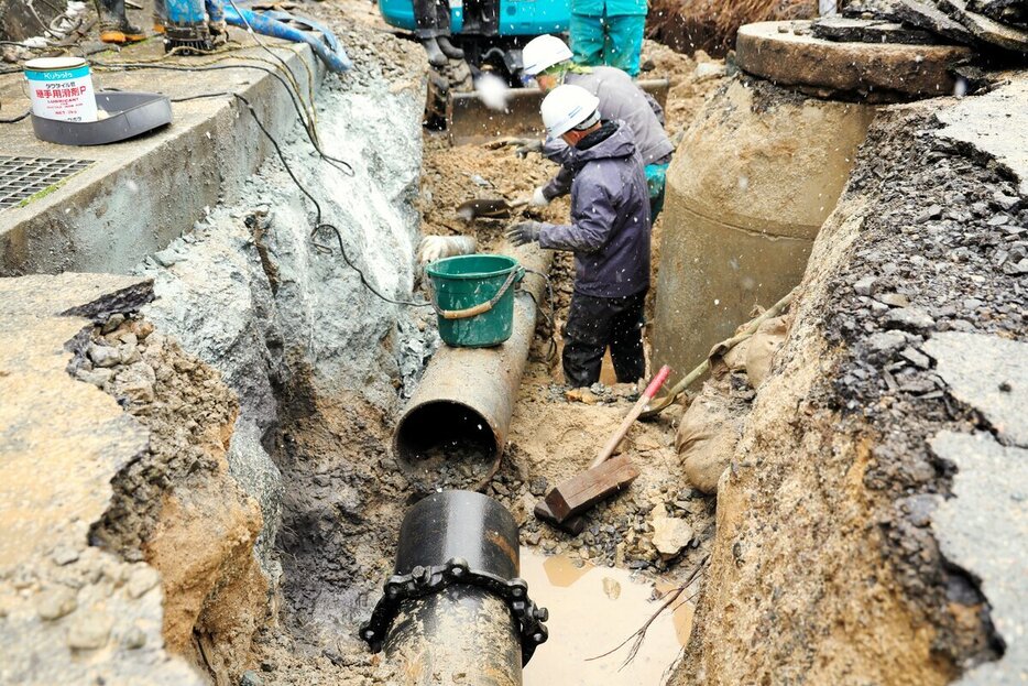 能登半島地震で破損した水道管の復旧工事に当たる作業員ら＝2024年1月15日、石川県輪島市