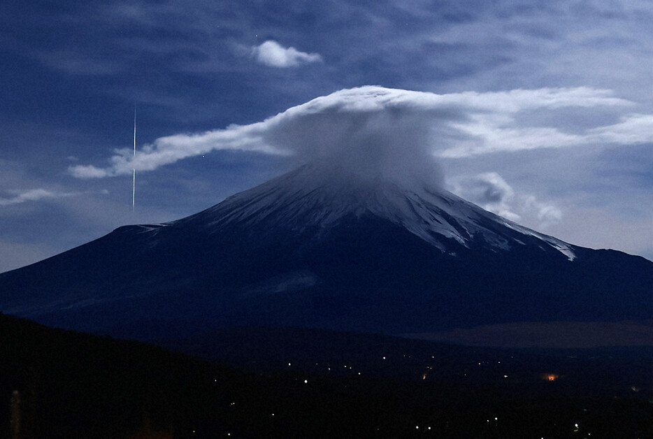 月明かりの中、富士山のそばに流れるふたご座流星群の流れ星＝山梨県山中湖村で2024年12月14日午前1時34分、手塚耕一郎撮影（5秒露光）