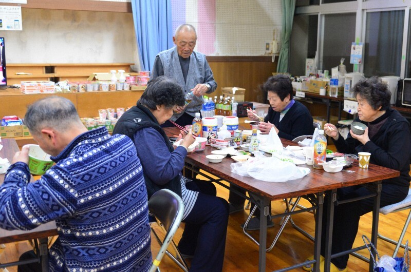 避難所で刺し身やカップ麺などを食べながら大みそかの夜を過ごす能登豪雨の被災者＝石川県珠洲市で2024年12月31日午後5時26分、阿部弘賢撮影