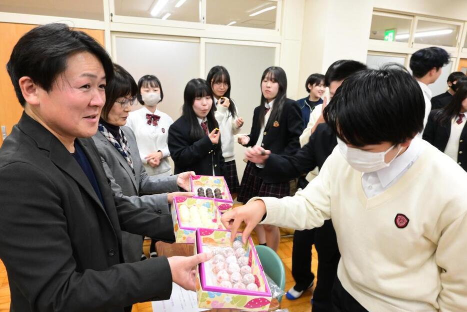 生徒らにチョコレートの試作品を配る深作勝己社長(左)=鉾田市鉾田