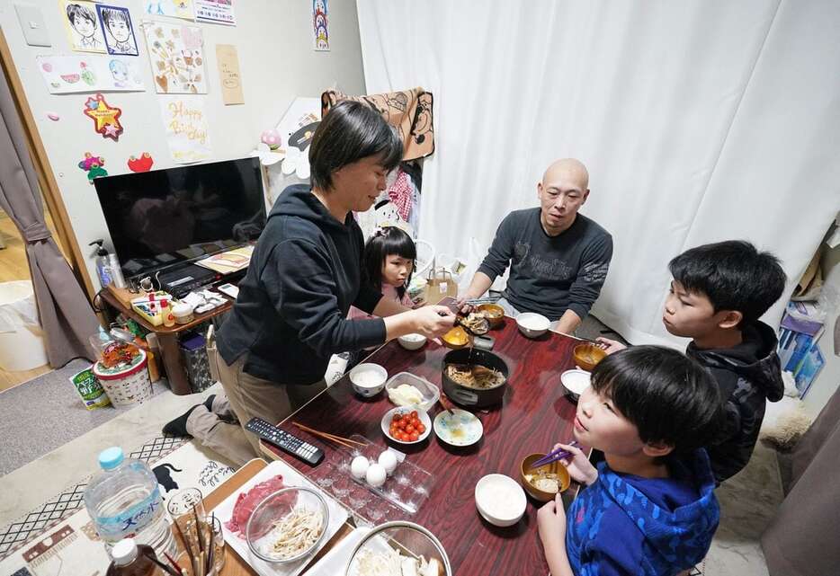 仮設住宅ですき焼きを食べながら大みそかを過ごす高野雅史さん一家＝31日午後、石川県輪島市町野町（恵守乾撮影）