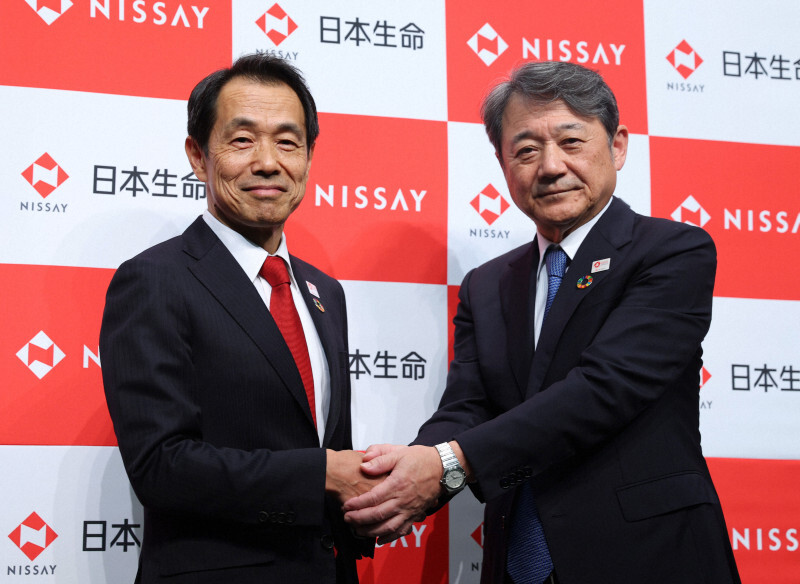 記者会見で握手する日本生命の朝日智司次期社長（右）と清水博次期会長＝東京都千代田区で2024年12月18日午後4時45分、猪飼健史撮影