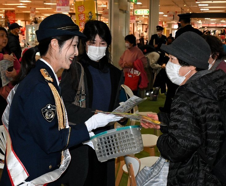 買い物客らに啓発グッズを配る遠藤さん（左）＝１３日、倉吉市山根のパープルタウン