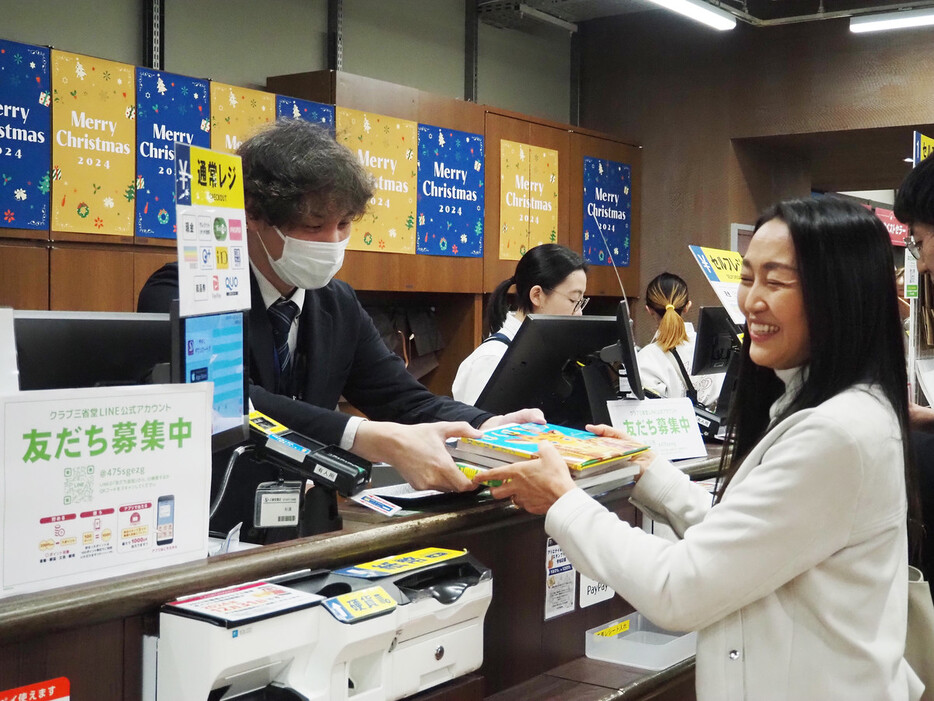 書店で購入した本を「ブックサンタ」に寄付する小野寺留奈子さん＝１１月２５日、東京都千代田区