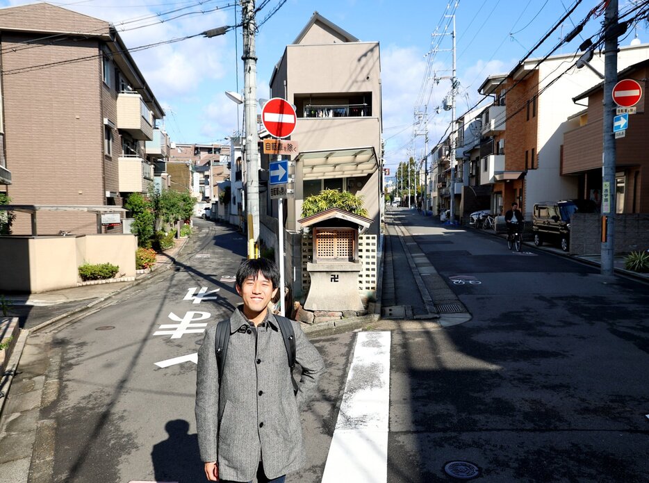 京都大近くのＹ字路を背にする重永さん。辺りは「密集地帯」で、まち歩きツアーの舞台だ（１１月中旬、京都市左京区）＝撮影・安達雅文