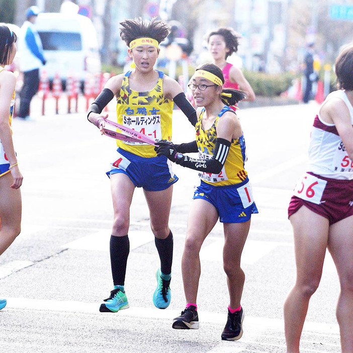 【女子の部】白鵬女子１区・勝呂（左）から２区沼田へのたすきリレー＝第１中継所