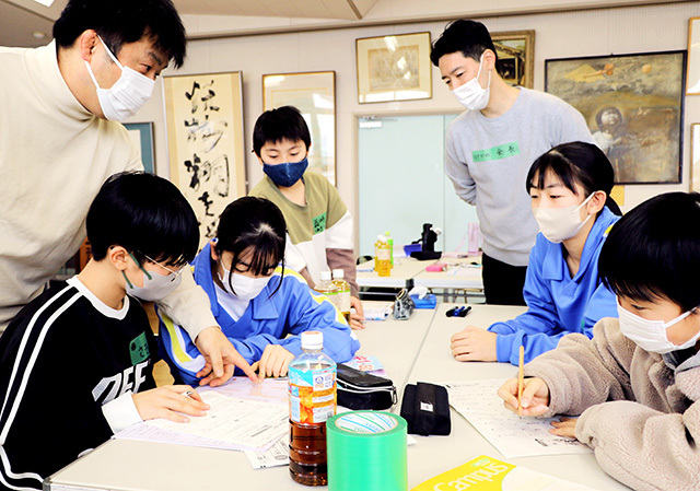 中学生らに教わりながら冬休みの宿題に取り組む小学生たち＝山形市出羽小