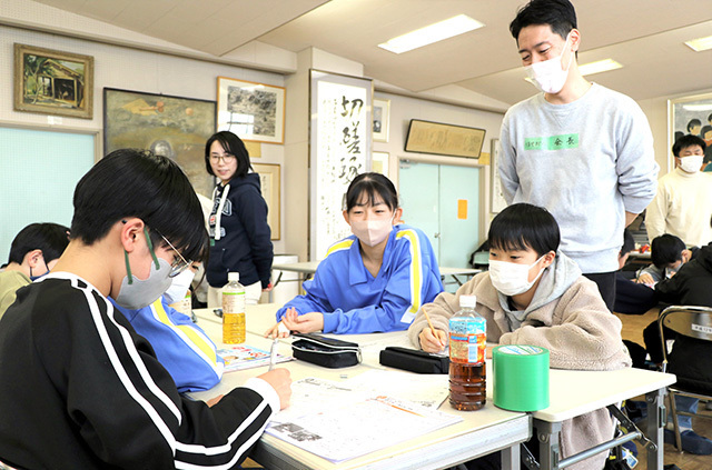 中学生らに教わりながら冬休みの宿題に取り組む小学生たち＝山形市出羽小