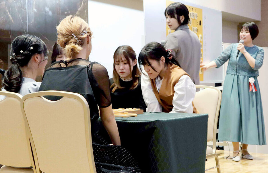 大阪府高槻市内で開催された「女流棋士発足５０周年記念パーティー　～WEST～」でペア将棋を指す（中央左から）山口仁子梨・稀良莉の女流一級姉妹と、解説の加藤桃子女流四段（右端）、今井絢女流初段（右から２人目）