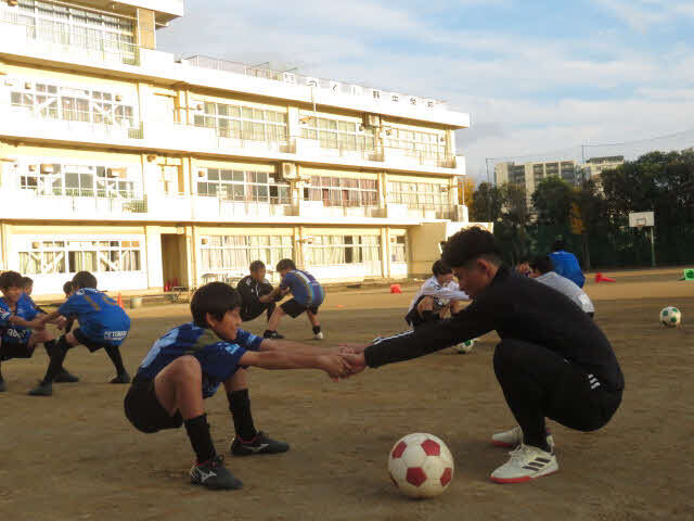 母校つくし野中学で子どもたちと体を動かす太田宏介さん（手前右）