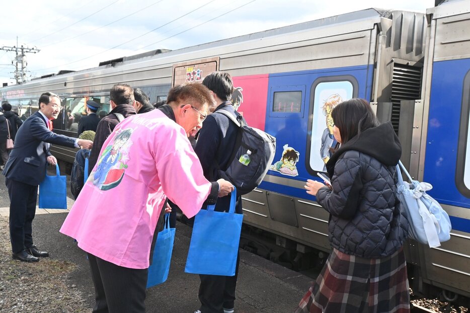 下車した乗客を出迎える平井知事（左奥）と手嶋町長（中央手前）＝１日、ＪＲ由良駅