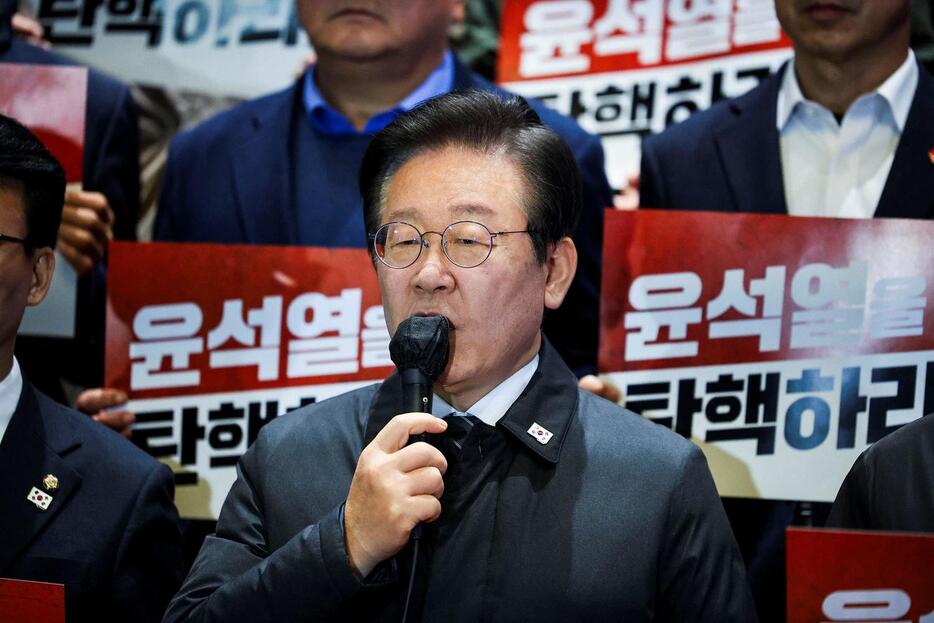 024年12月7日、韓国ソウルの国会で記者会見に出席した、韓国の第1野党、共に民主党の李在明代表と国会議員ら（ロイター）