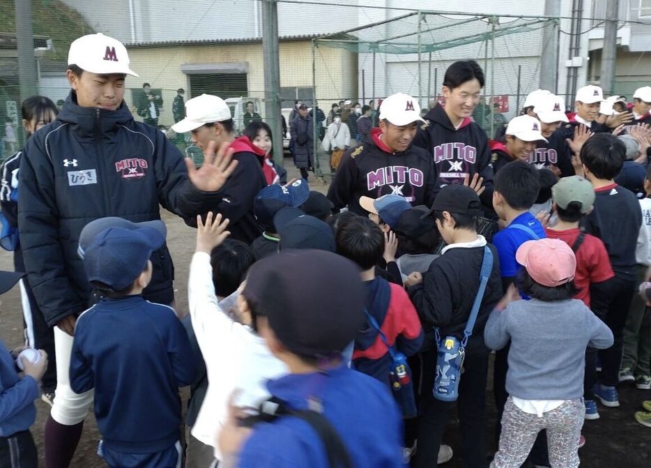 小学生たちとハイタッチでふれあう水戸一ナイン（提供写真）