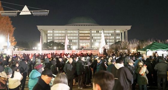 非常戒厳解除要求決議案が国会本会議を通過した４日深夜、ソウルの国会正門前に集まった市民が尹大統領を糾弾している。チョン・ミンギュ記者