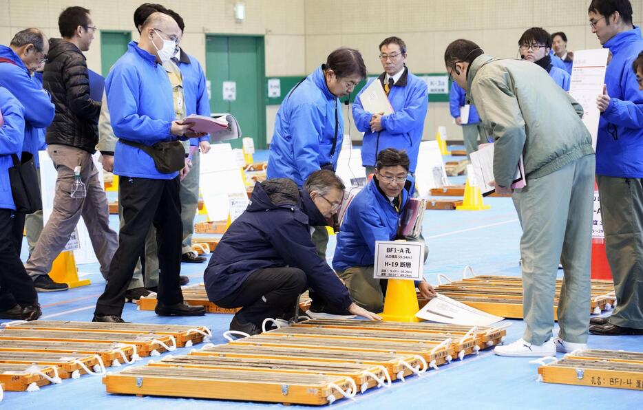 ボーリング調査の試料を調べる原子力規制委の山岡耕春委員（中央手前）ら＝17日午前、静岡県御前崎市