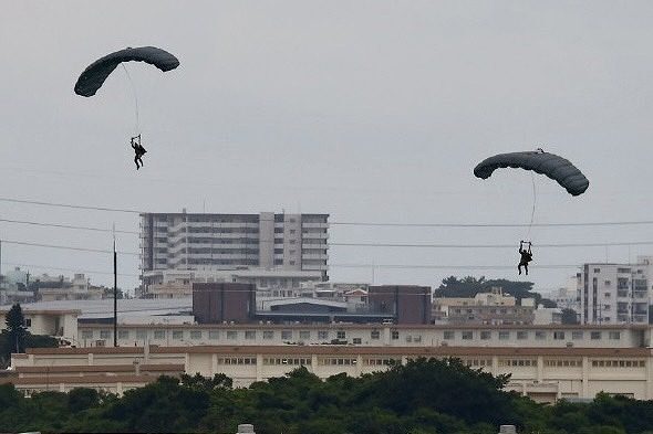 パラシュートで降下する米兵＝18日午後3時56分、米軍嘉手納基地（大城直也撮影）