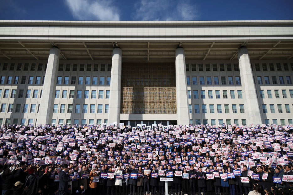 １２月４日、韓国の野党６党は尹錫悦大統領が戒厳令を発令し数時間後に解除したことを受けて、大統領弾劾訴追案を国会に提出した。写真は同日、韓国議会前で尹氏に抗議する市民や議員（２０２４年　ロイター/Kim Hong-Ji）