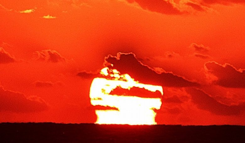 渡嘉敷島から見た本島南部の喜屋武岬沖合の水平線上の「だるま朝日」＝6日午前7時7分ごろ、渡嘉敷島の儀津崎海岸