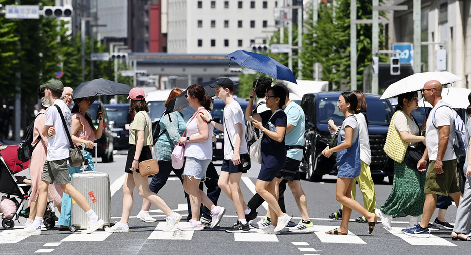 7月、気温が上昇した東京・銀座を行き交う人たち