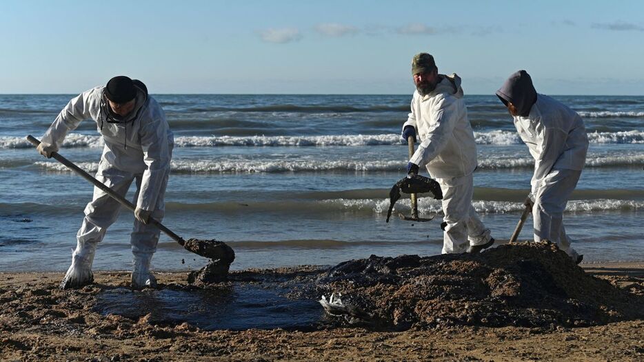 海岸に流出した重油の清掃作業に取り組むボランティア＝２０日、ロシア・アナパ近郊