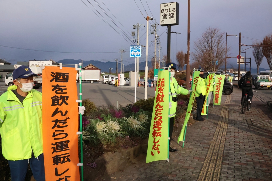 のぼり旗を持ち安全運転を呼びかける松代安協の会員