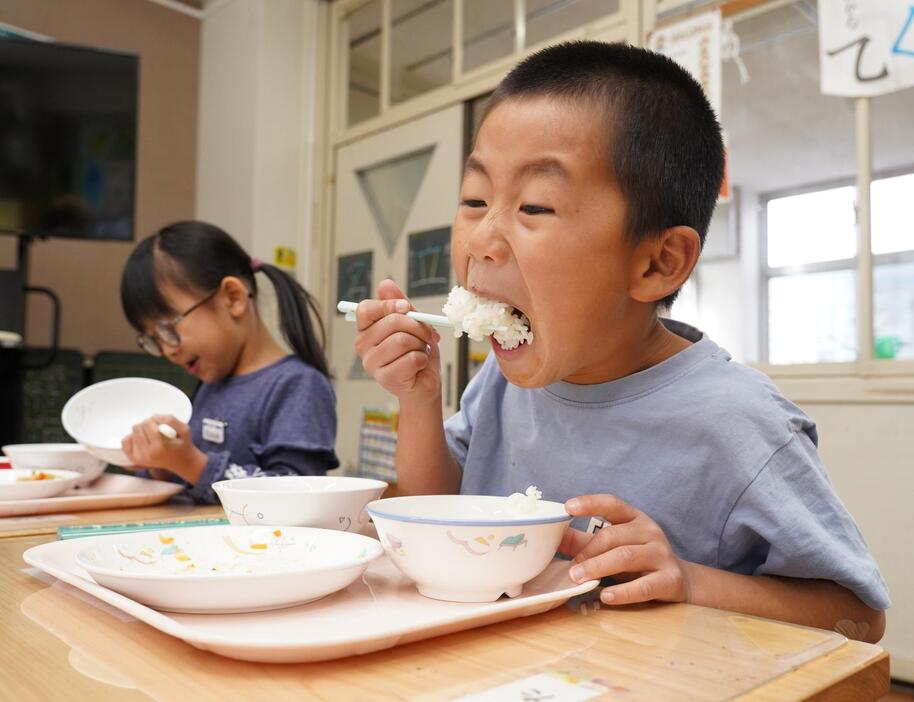 「あーん」。給食に提供された「有機チャレンジ米」を頬張る児童たち＝兵庫県丹波篠山市今田町下小野原で