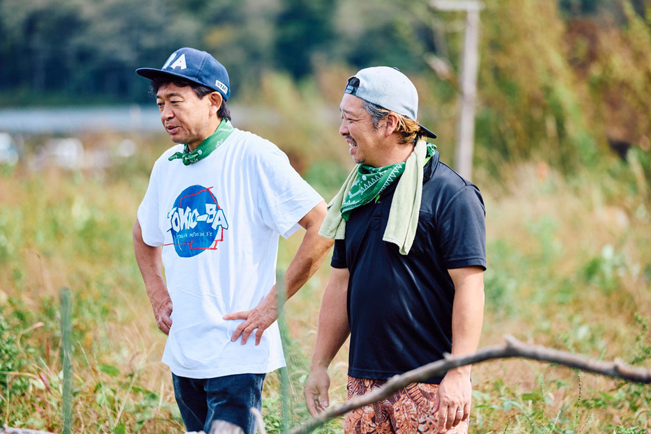 城島さんと畑を見学するニッケイファームの大竹さん。大竹さんの農場では年間約100種類の作物を無農薬で栽培している