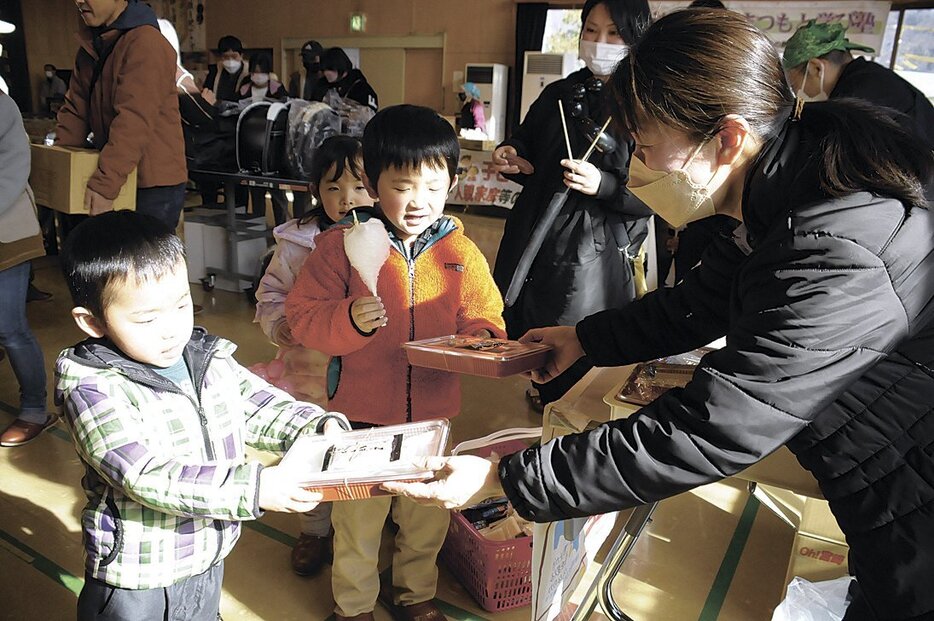 年越し用の手打ちそばを受け取る子供たち