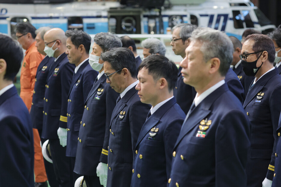 日本航空と海上保安庁の航空機が衝突炎上した事故から１年を前に、追悼式で黙とうする海保職員ら＝２３日午前、東京都大田区