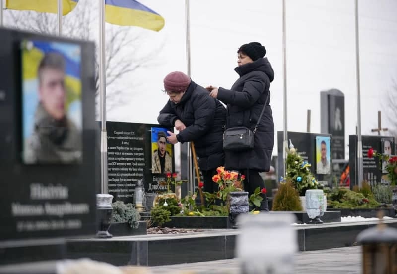 ロシアのウクライナ侵攻開始から２年となり、キーウ近郊ブチャの共同墓地を訪れた遺族ら＝２０２４年２月（共同）