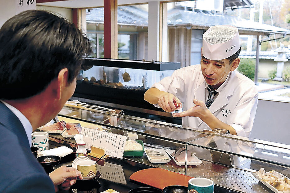 自慢のすしを振る舞う堀納さん＝七尾市和倉町