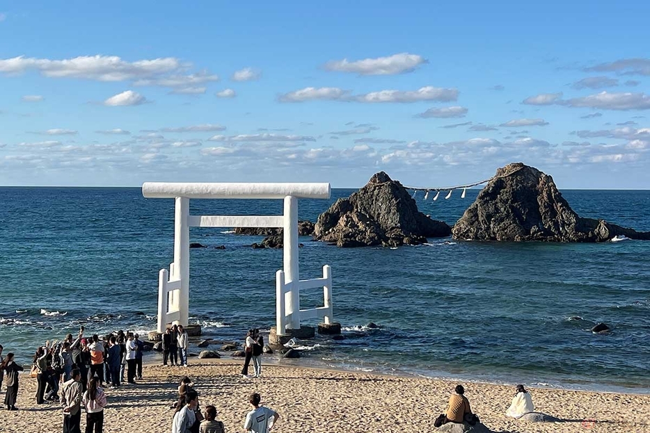 青い海と空、夫婦岩を背景に映える白い鳥居。糸島半島屈指の観光スポットである「桜井二見ヶ浦」