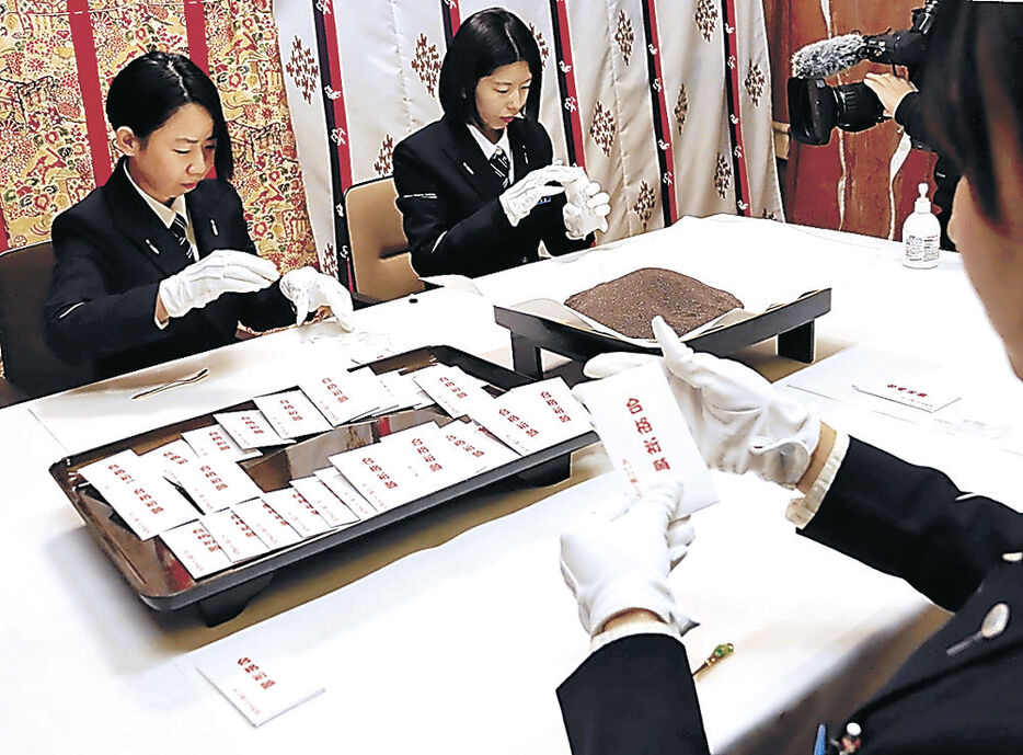 お守りの砂を袋に詰めるあいの風とやま鉄道社員＝高岡関野神社