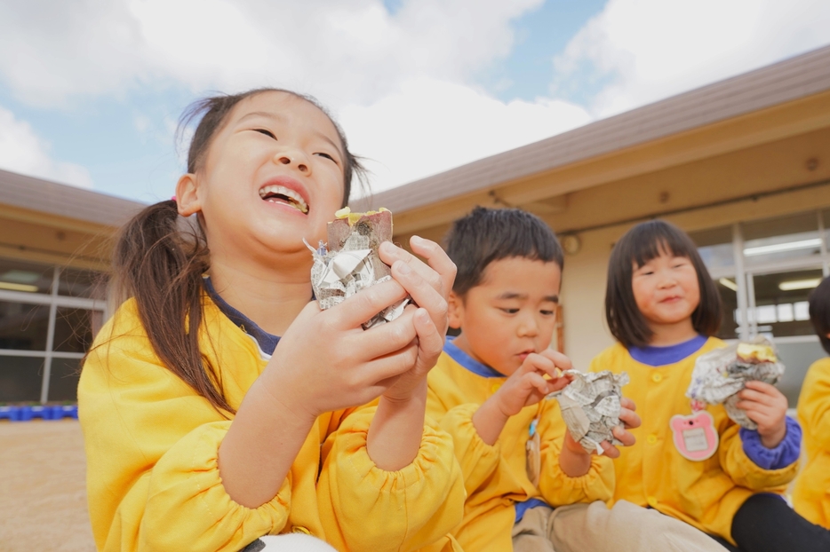 「おいしいー」。焼き芋を頬張る園児たち＝2024年12月4日午前10時30分、兵庫県丹波篠山市日置で